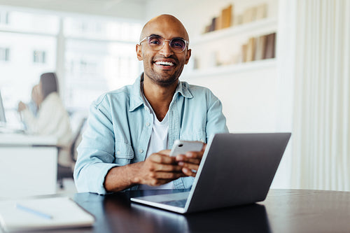 Business man using a mobile phone and sitting in an office