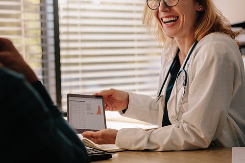 Female doctor showing test results to patient and smiling