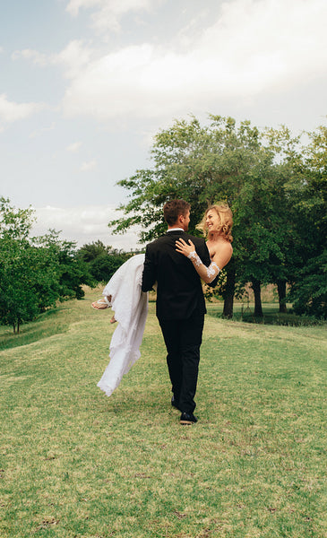Bridegroom carrying beautiful bride in his arms