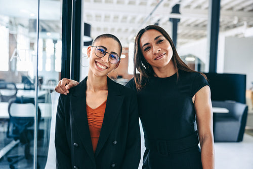 Female colleagues standing together in an office