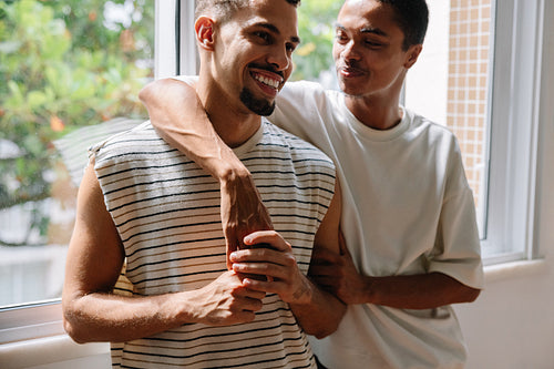 Happy couple sharing a tender moment by a bright window