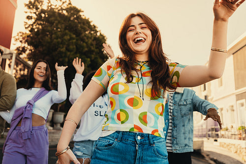 Group of friends enjoying outdoor fun and dancing on a sunny day
