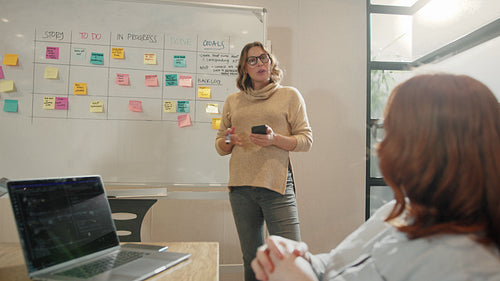 Scrum master having a discussion with her team in an office