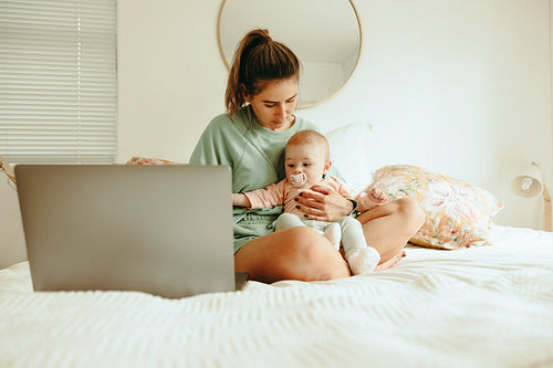 Student mom holding her baby while preparing for exams