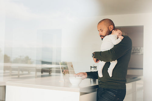 Father with little boy in kitchen cooking food
