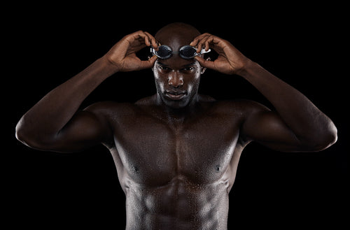 Young muscular swimmer with goggles