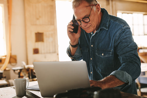 Senior male carpenter on the phone