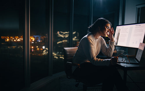 Computer fatigue: Exhausted business woman working overtime in an office