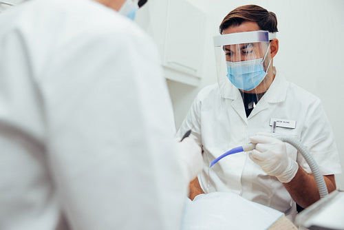 Dental doctor treating patient in his dentistry