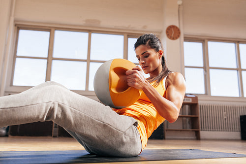 Muscular young woman doing crossfit workout in gym