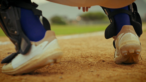 Catcher signals pitch from the dirt mound