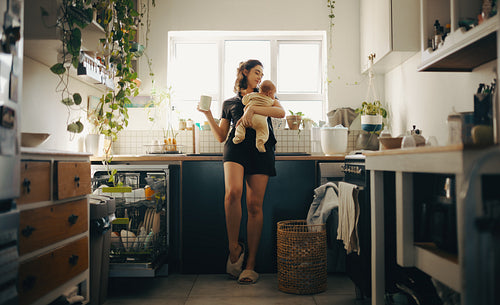 Mother with baby in a cozy kitchen.