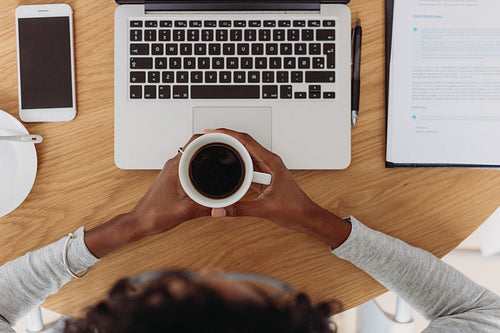 Businesswoman working with coffee in hand