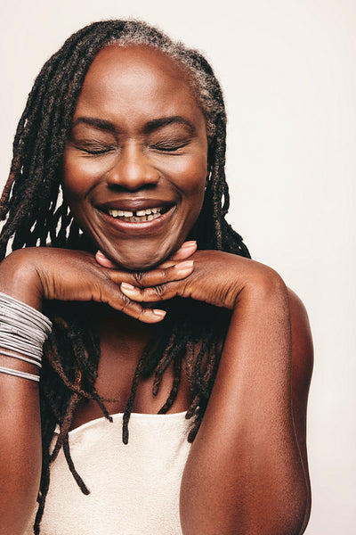 Happy mature woman smiling cheerfully with her eyes closed