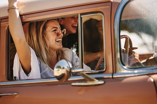 Woman with friends enjoying a road trip drive