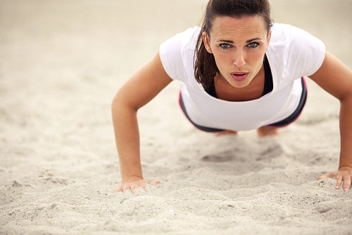 Woman Doing Push Up Exercise on the Beach