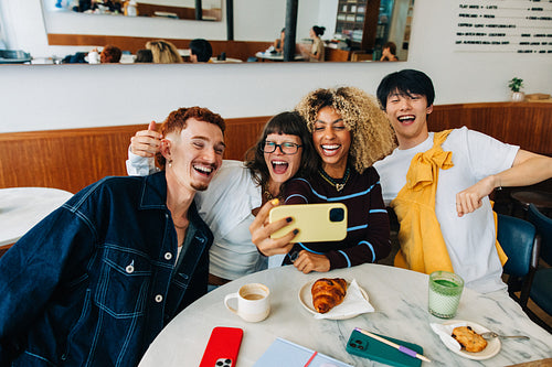 Young friends taking a selfie together in cafe
