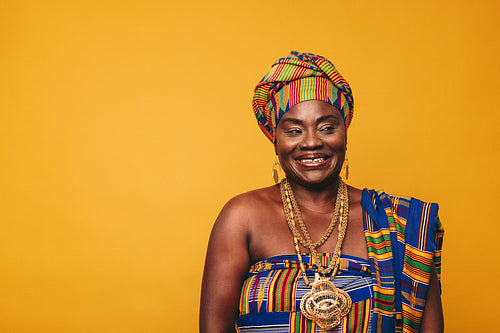 Smiling African woman wearing elegant traditional clothing in a studio