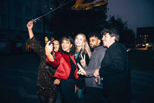 Group of friends taking a selfie during a festive evening outing