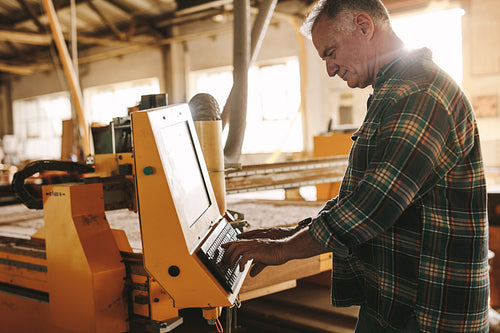 Carpenter programming a cnc wood working machine