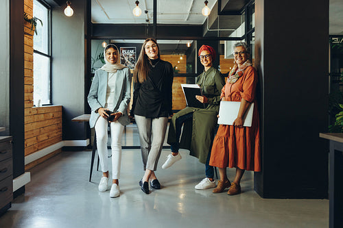 Successful female designers smiling at the camera in an office