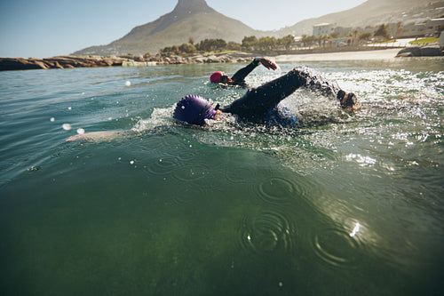 Athletes practicing for triathletic race in lake