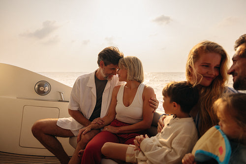 Grandparents and family relaxing together on a yacht during sunset