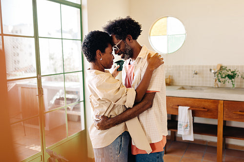Romantic Afro-Brazilian couple bonding in intimate kitchen moment