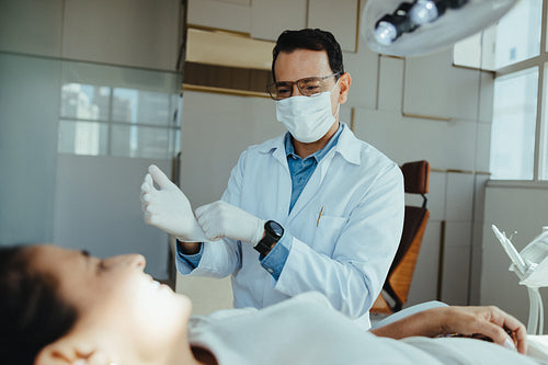 Dentist prepares for dental checkup with adult female patient