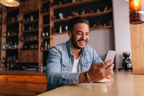 Man having video chat on smart phone at cafe