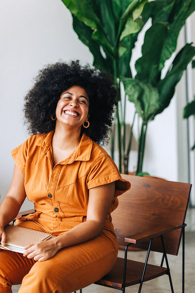 Businesswoman with Afro hair smiling happily in an office