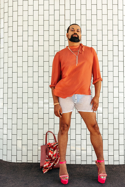 Fashionable drag queen standing against a white background
