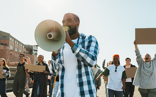 Diverse group of protesters raising their voices and chanting for a cause