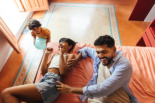 Happy father and daughter playing together with family at home