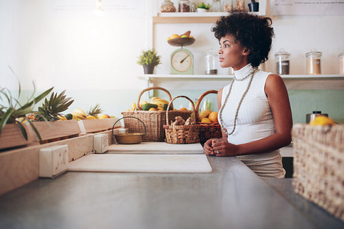 Beautiful young woman behind juice bar counter