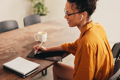 Businesswoman working from home using digital tablet