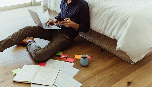 Businessman spread out working at home with his laptop