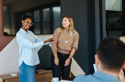 Two colleagues sharing moments of joy during a casual office meeting