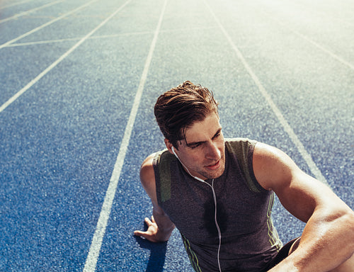 Sprinter relaxing on running track
