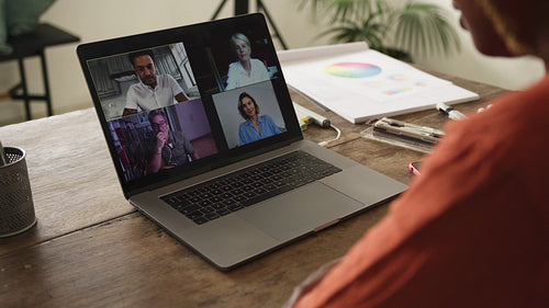 Female artist waving at her business clients on a video call
