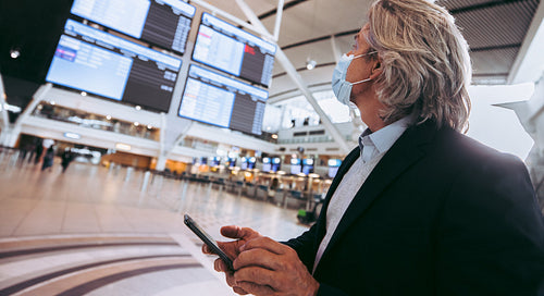 Businessman checking his flight timing on information screen