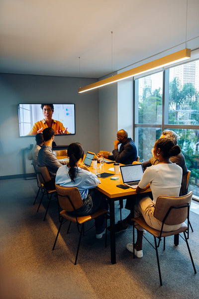 Business professionals in a meeting room conducting a video conference discussion