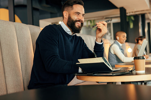 Cheerful businessman taking a phone call in a co-working space