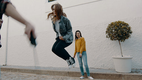Girls playing with skipping rope outdoors