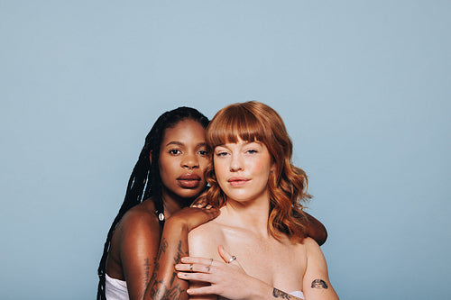 Confident women with different skin tones standing together