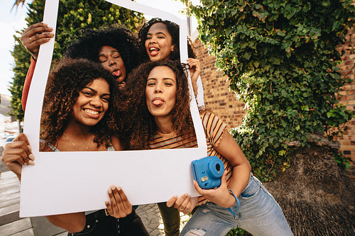 Girls posing with blank picture frame