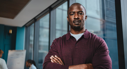 Confident black male entrepreneur standing in a boardroom meeting