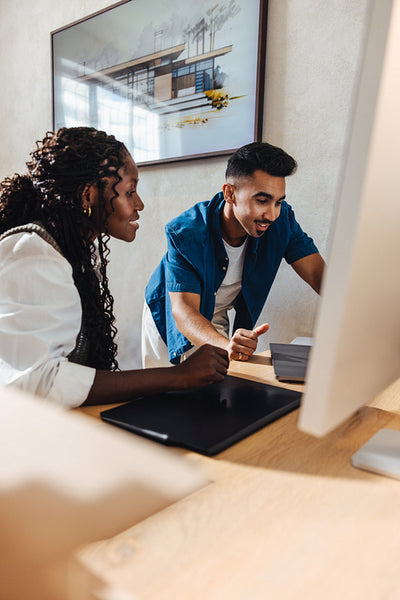 Young professionals discussing architectural design at a small architecture firm workspace