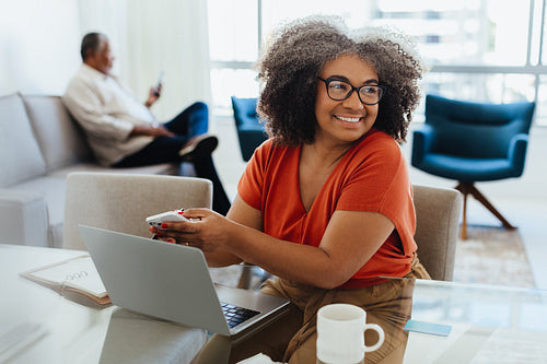 Confident senior woman working from home with laptop and phone