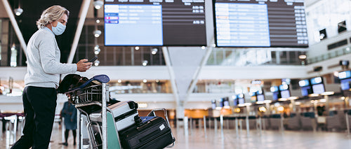 Traveler using phone at airport during pandemic